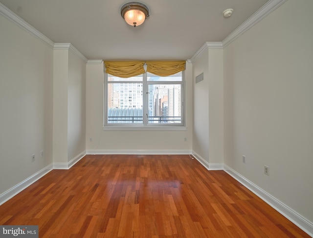 spare room featuring ornamental molding and hardwood / wood-style floors