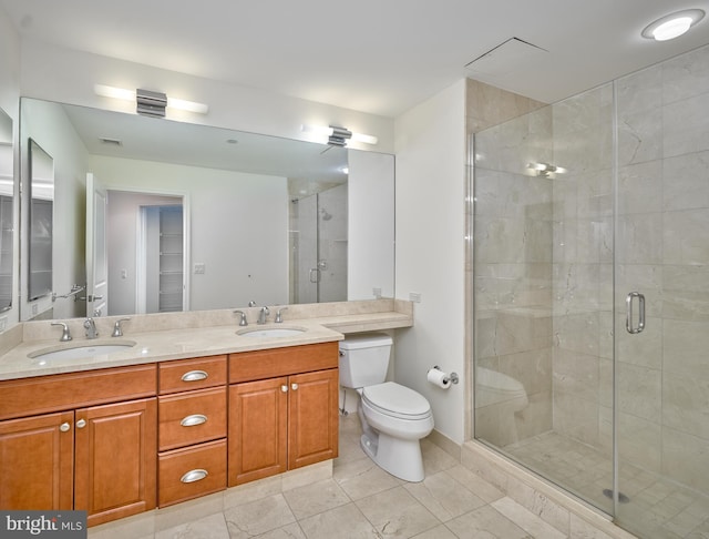 bathroom with a shower with door, vanity, and toilet