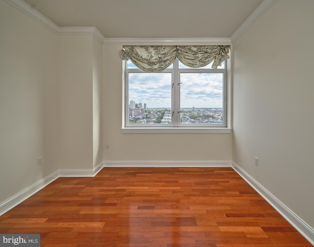 spare room with ornamental molding and hardwood / wood-style floors