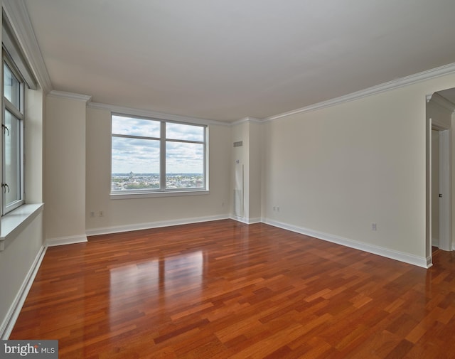 empty room with ornamental molding and hardwood / wood-style flooring