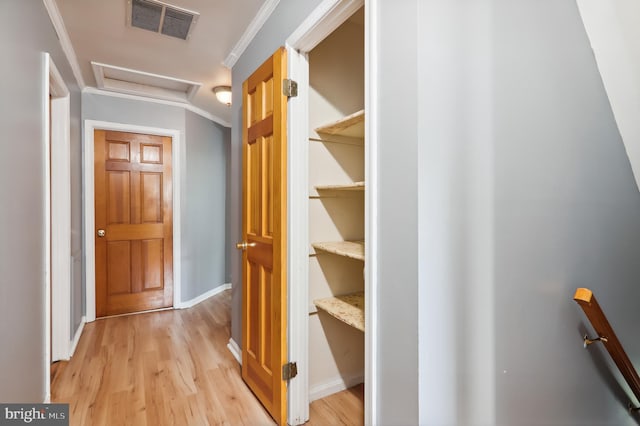 hallway with light hardwood / wood-style flooring and crown molding