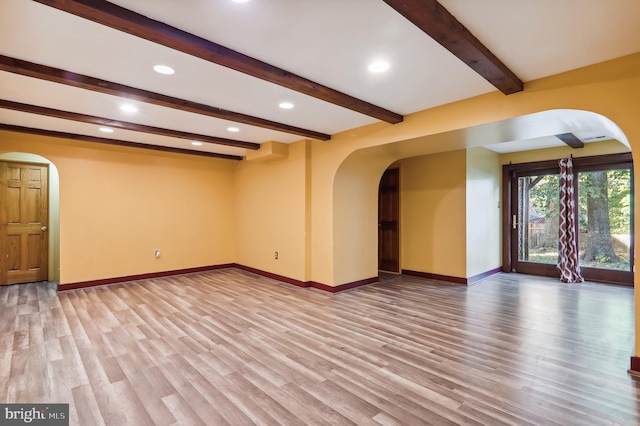 unfurnished living room featuring hardwood / wood-style floors and beamed ceiling