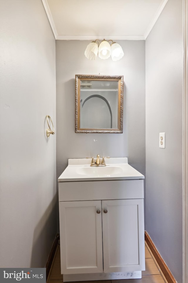 bathroom featuring vanity, hardwood / wood-style flooring, and crown molding