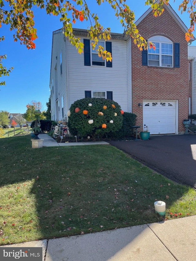 traditional home with an attached garage, driveway, a front lawn, and brick siding