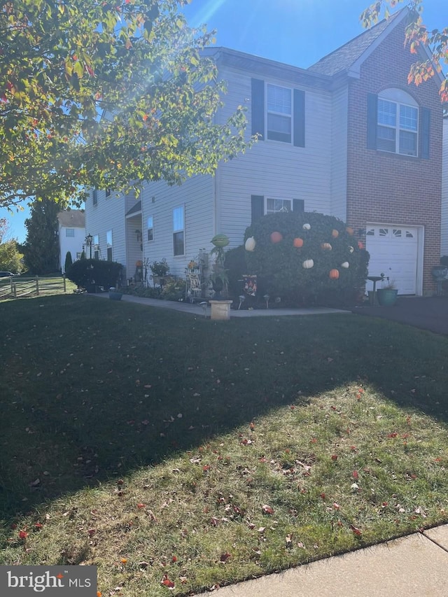 traditional home featuring a garage, brick siding, and a front lawn