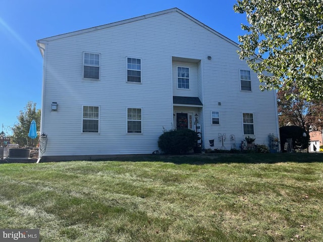 rear view of house featuring a yard