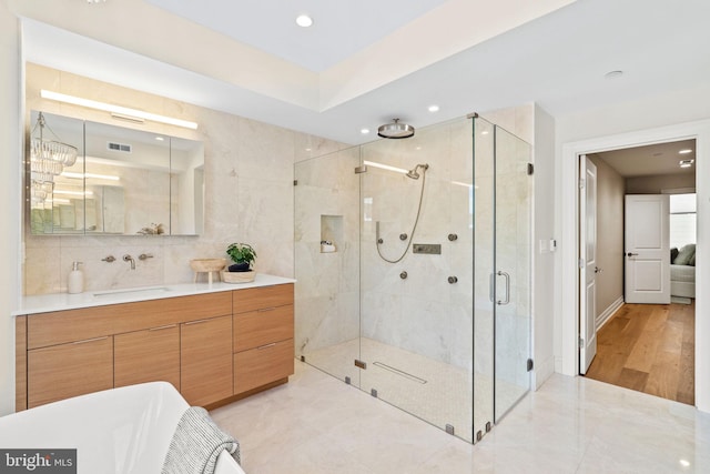 bathroom featuring vanity, a chandelier, a shower with door, and hardwood / wood-style floors