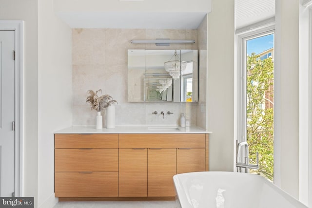 bathroom featuring tasteful backsplash, a soaking tub, and vanity