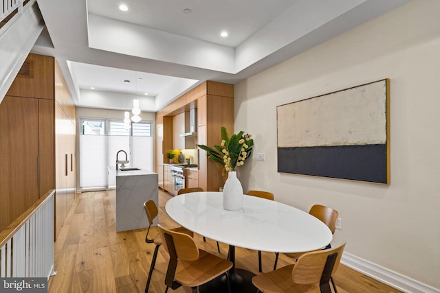 dining area featuring light wood finished floors, baseboards, and recessed lighting