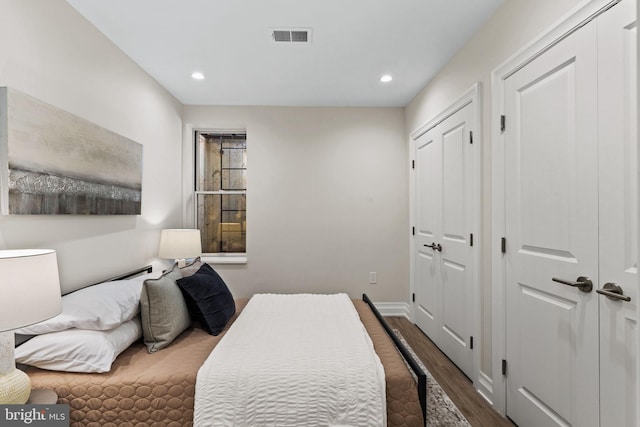 bedroom with recessed lighting, dark wood-style flooring, visible vents, and baseboards