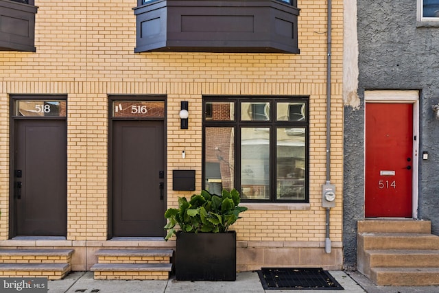 entrance to property with elevator and brick siding