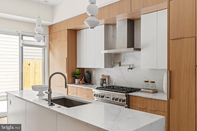 kitchen featuring white cabinets, pendant lighting, light stone countertops, and wall chimney exhaust hood