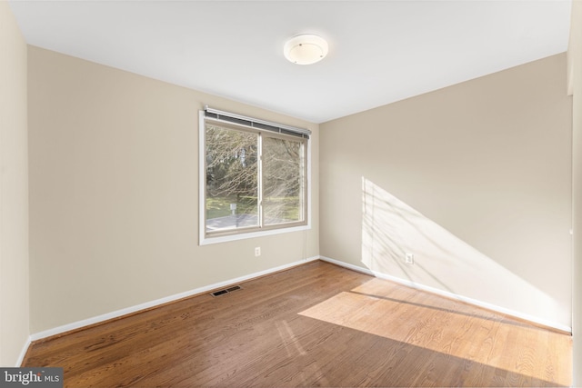 unfurnished room with hardwood / wood-style flooring