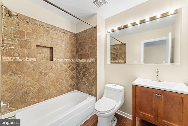 full bathroom featuring tiled shower / bath, hardwood / wood-style floors, vanity, and toilet