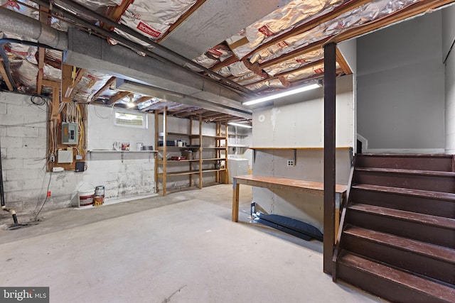 basement with electric panel and washer / dryer