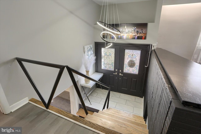 entryway featuring french doors, an inviting chandelier, and hardwood / wood-style floors