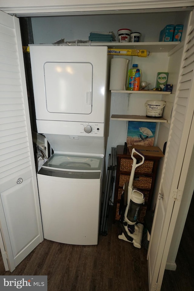 washroom with stacked washer / dryer and dark hardwood / wood-style flooring