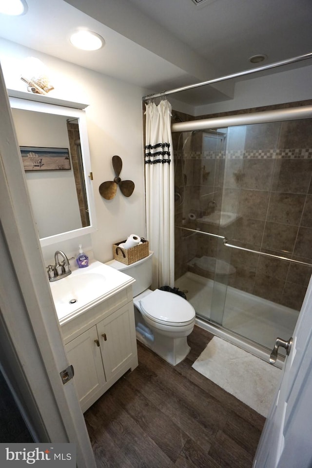 bathroom featuring vanity, toilet, wood-type flooring, and curtained shower