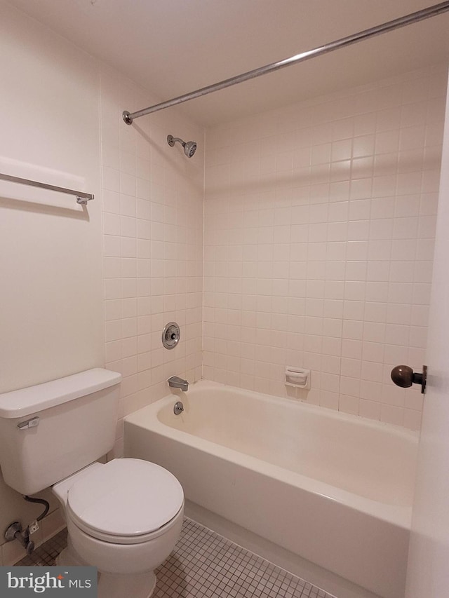 bathroom with toilet, tiled shower / bath, and tile patterned floors