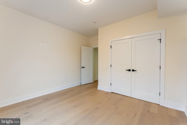 unfurnished bedroom with a closet and light hardwood / wood-style flooring