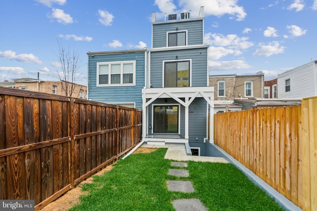 rear view of house featuring a yard