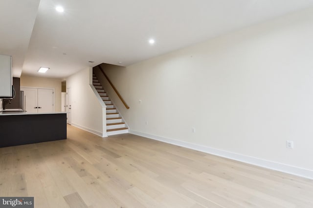 unfurnished living room with sink and light hardwood / wood-style floors