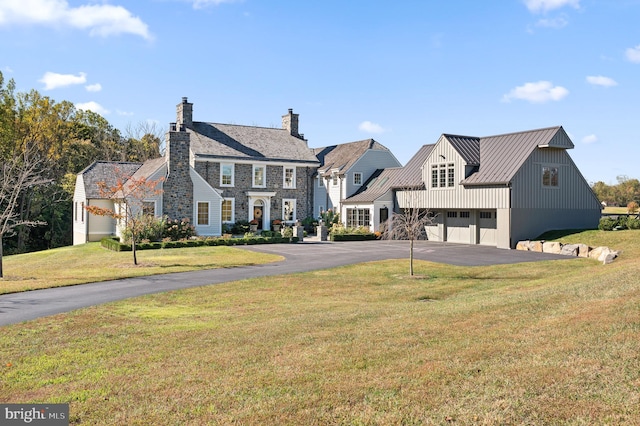 1484 W Strasburg Rd, West Chester, PA 19382 - view of front of home with a standing seam roof, aphalt driveway, a front lawn, metal roof, and a garage