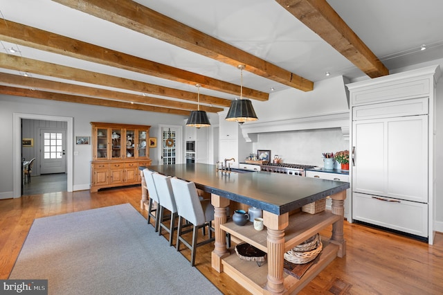 1484 W Strasburg Rd, West Chester, PA 19382 - kitchen with paneled built in refrigerator, open shelves, a sink, dark countertops, and an island with sink