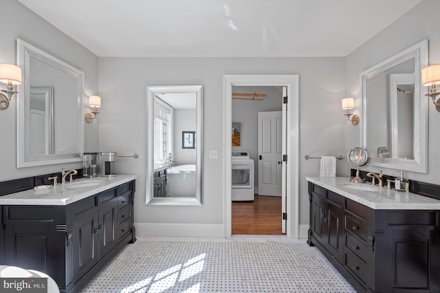 1484 W Strasburg Rd, West Chester, PA 19382 - bathroom featuring washer / clothes dryer, a sink, and two vanities