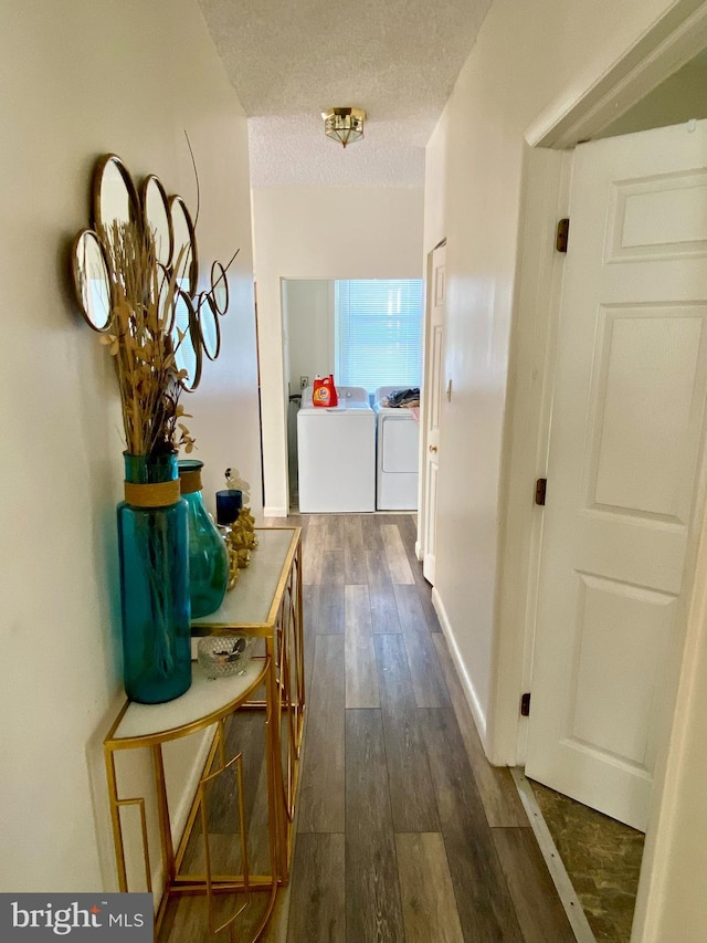 hallway featuring washer and dryer, dark hardwood / wood-style floors, and a textured ceiling