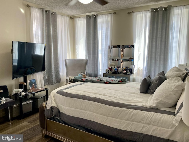 bedroom with ceiling fan, a textured ceiling, and hardwood / wood-style floors