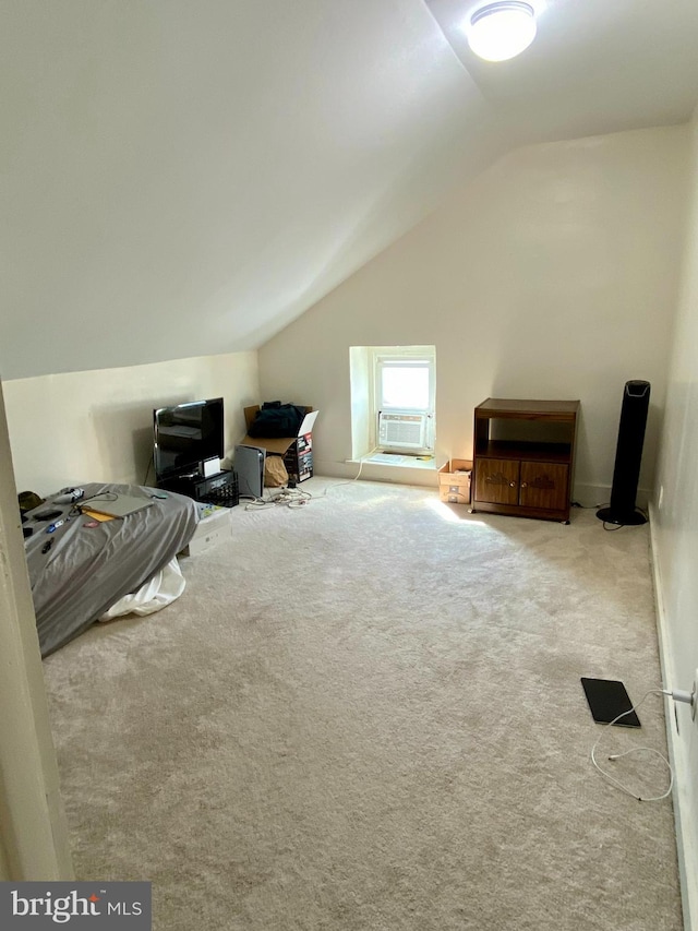 additional living space featuring light colored carpet and vaulted ceiling