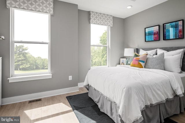 bedroom with light hardwood / wood-style flooring and multiple windows