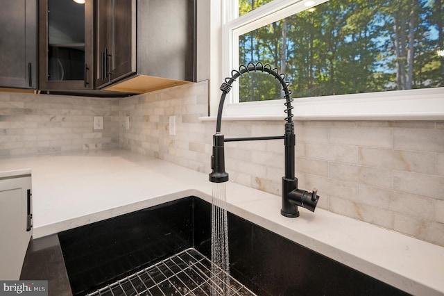 details with dark brown cabinets, backsplash, and sink