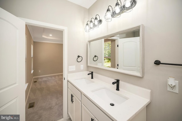 bathroom with a tray ceiling and vanity