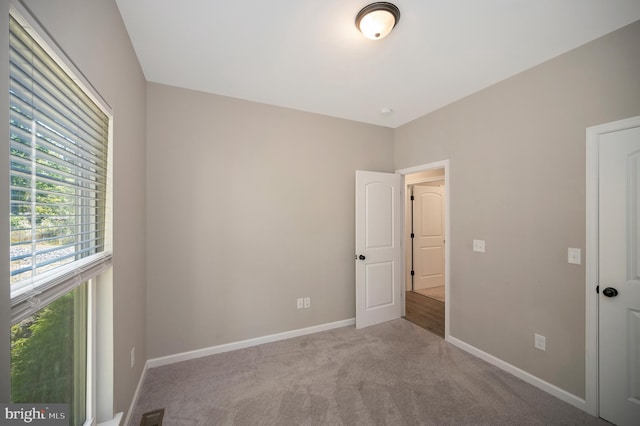 unfurnished bedroom featuring light carpet