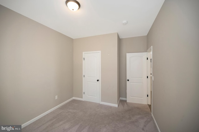 unfurnished bedroom with a closet and light carpet