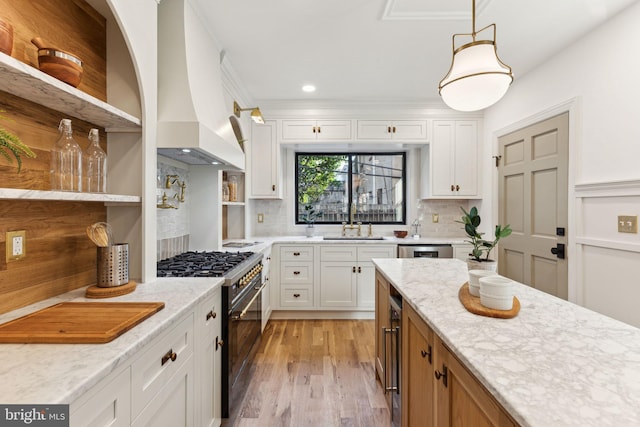 kitchen with white cabinetry, custom range hood, stainless steel range, light stone countertops, and decorative backsplash