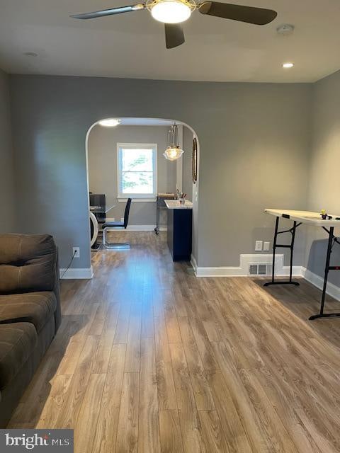 living room with ceiling fan and light hardwood / wood-style floors