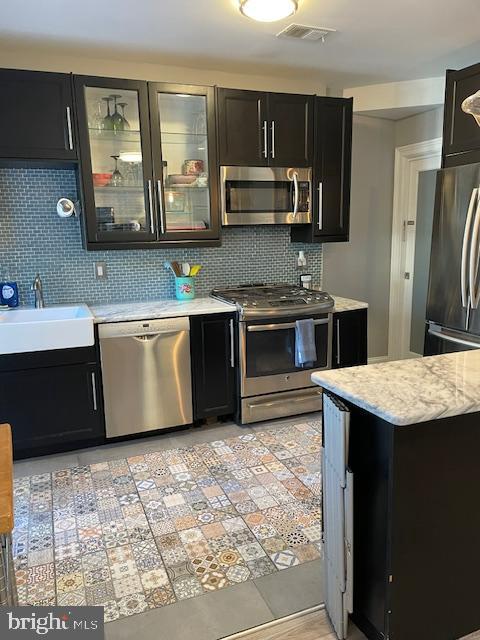 kitchen featuring appliances with stainless steel finishes, sink, and decorative backsplash