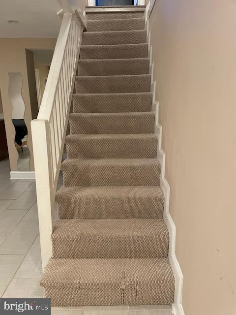 stairs featuring tile patterned flooring