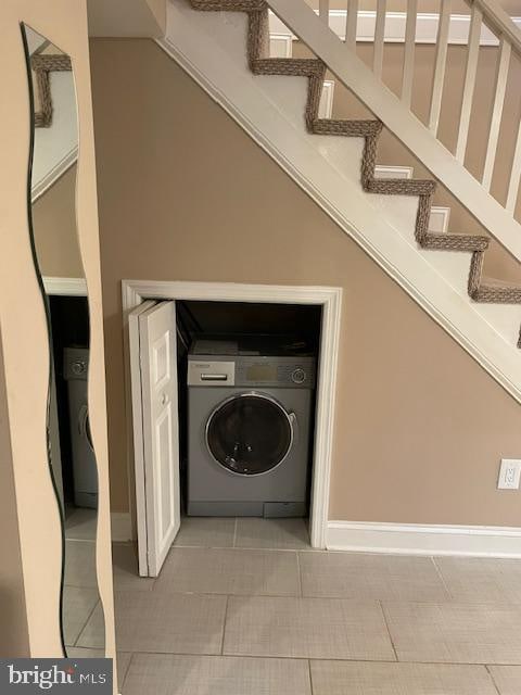 laundry area with light tile patterned floors and washer / dryer