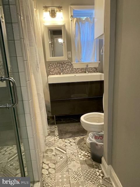 bathroom featuring vanity, toilet, tasteful backsplash, a shower with curtain, and tile patterned flooring