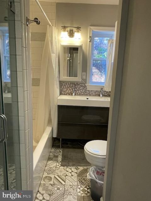 full bathroom featuring shower / tub combo with curtain, vanity, tasteful backsplash, tile patterned floors, and toilet