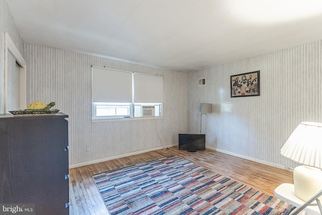 unfurnished room featuring cooling unit and hardwood / wood-style flooring