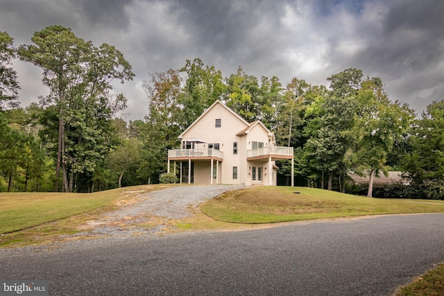 view of front of home featuring a balcony and a front lawn