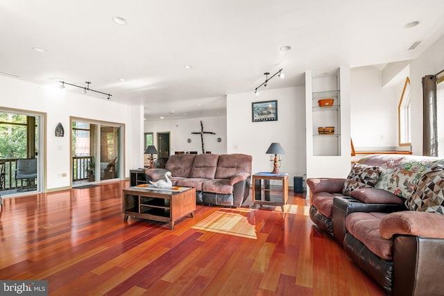 living room with wood-type flooring and track lighting