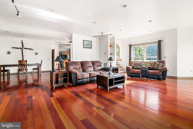 living room featuring a barn door, wood-type flooring, and rail lighting