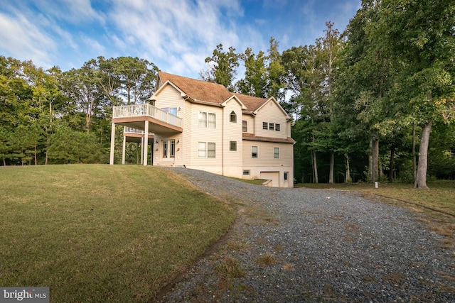 back of property featuring a garage and a lawn