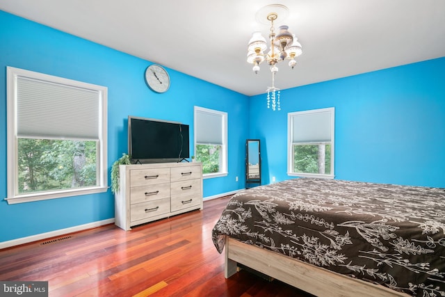 bedroom with dark hardwood / wood-style flooring and a chandelier